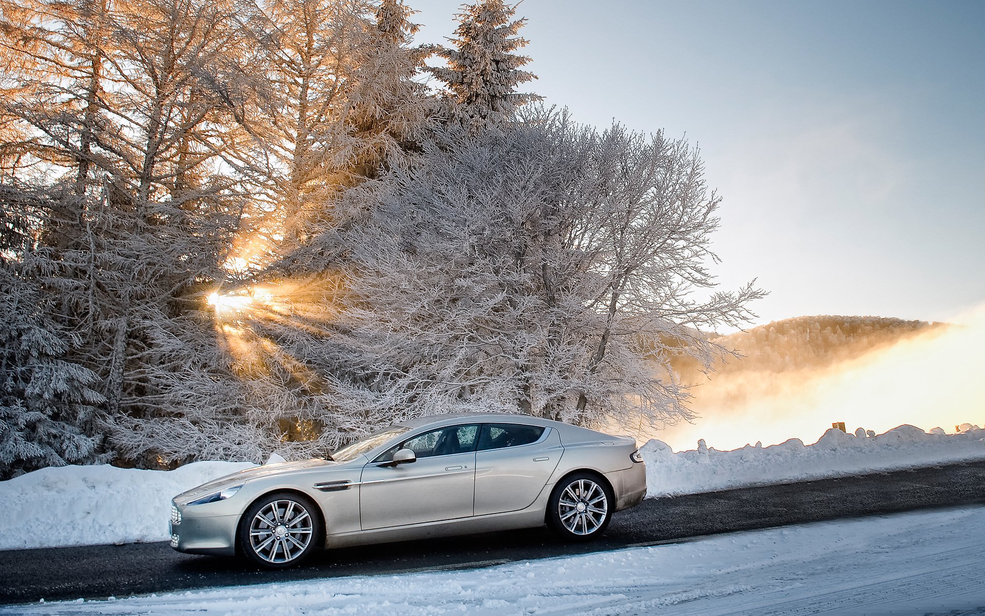 aston martin rapide aston martin rapid limousine seitenansicht winter schnee bäume himmel sonne