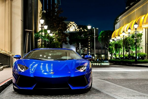 Lamborghini azul en la calle de la noche en el fondo de las linternas