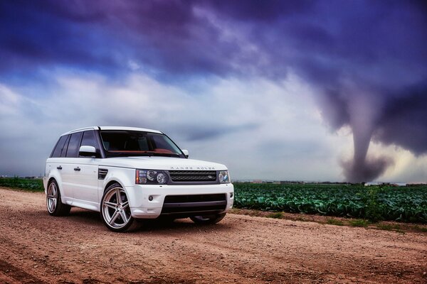 A white land rover. Tornado. Road. Disks