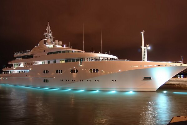 White yacht at the pier against the night sky