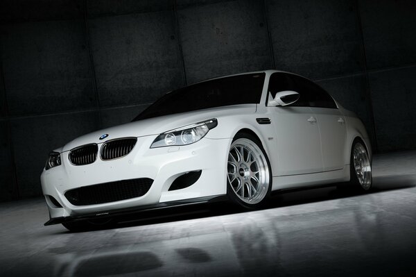 Bmw m5 with silver wheels stands in front