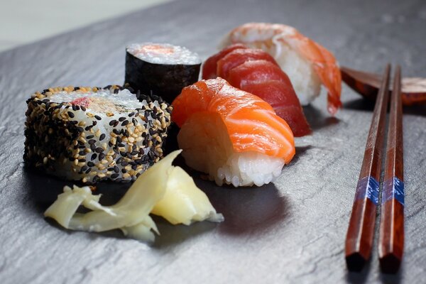 Auf dem Tisch liegen verschiedene Sushi mit Stäbchen