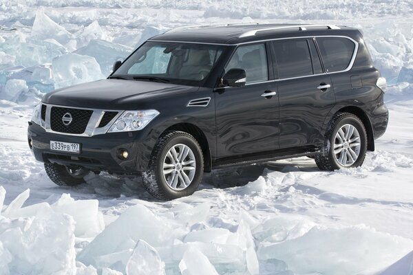 Nissan Patrouillekraft auf Schnee Hintergrund