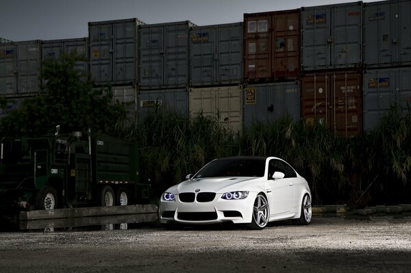 White car on the background of containers