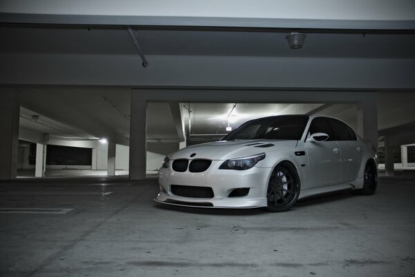 Un BMW M5 blanco en el estacionamiento. Vista frontal