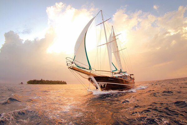 Schiff mit weißen Segeln auf Sonnenuntergang Hintergrund