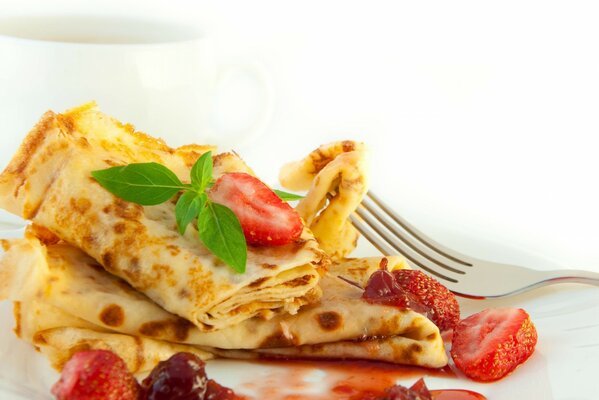 Pancakes with strawberry jam on a white background