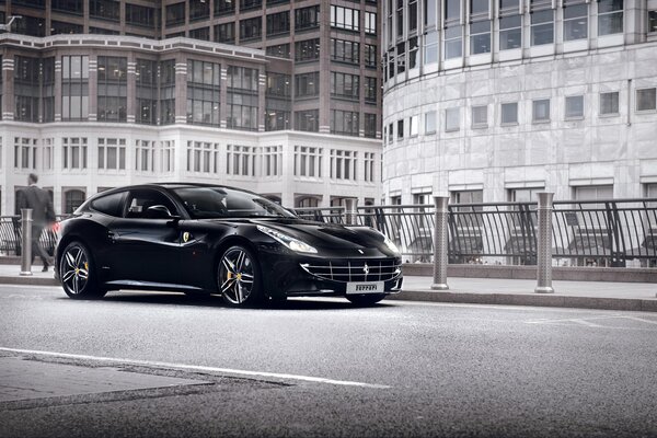 Un Ferrari de color negro en el fondo de la carretera