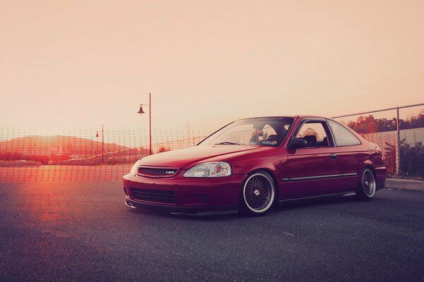 Red Honda Civic car on sunset background