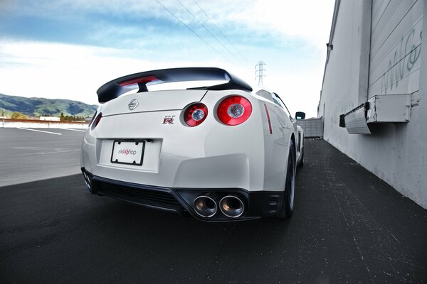 Une nissan R35 blanche sur la piste au pied des montagnes