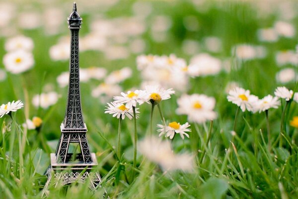 Statuette of the Eiffel Tower on the chamomile field