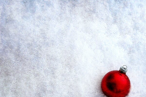 Boule rouge sur la couverture de neige