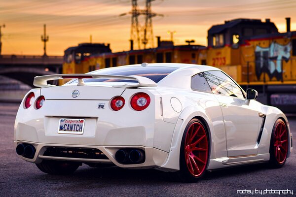 Voiture blanche Nissan avec roues rouges