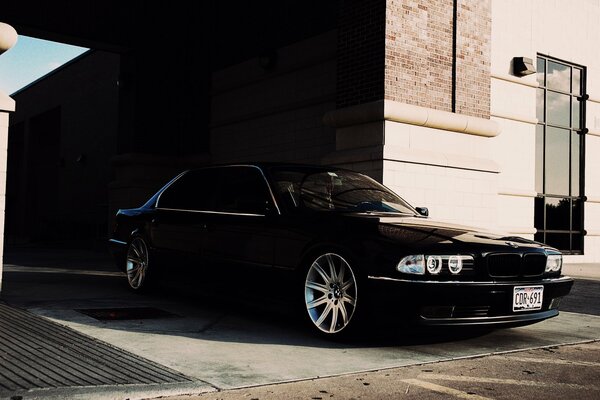 A black car outside a building in the sun