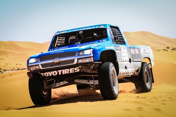 A racing car at a competition in the sandy desert