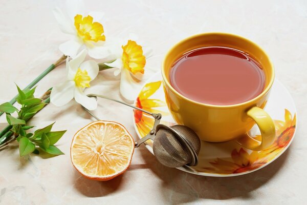 Tea with lemon in a beautiful yellow cup and saucer