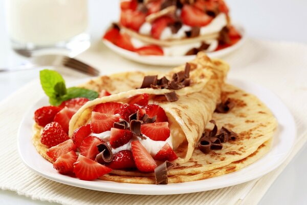 Leckere Pfannkuchen mit Erdbeeren in Schokolade