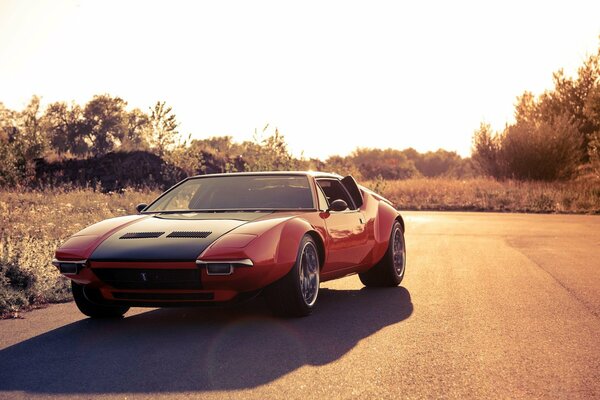 On the autumn road - a red sports car