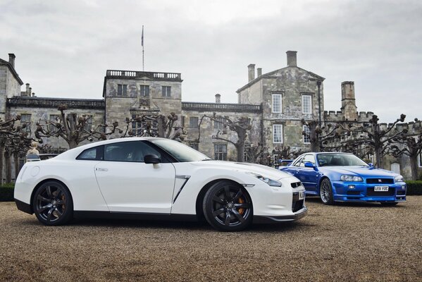 Nissan blanc et bleu sur fond de belle maison avec des arbres