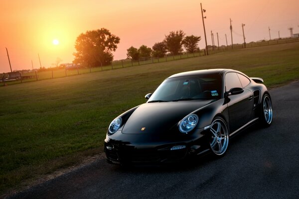 Schwarzer Porsche 911 Turbo bei sonnigem Sonnenuntergang