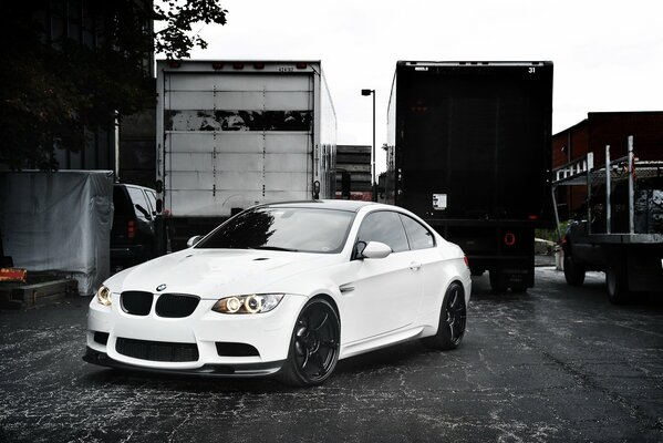 White BMW next to with trucks