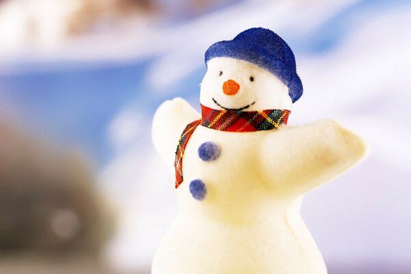 Ein Schneemann in einem blauen Hut mit ausgebreiteten Armen