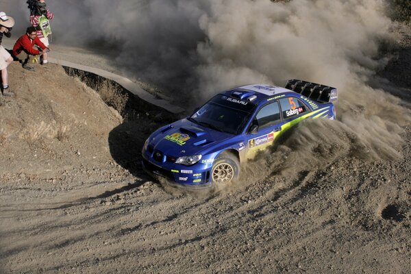 Blue subaru impreza goes into a turn at the races