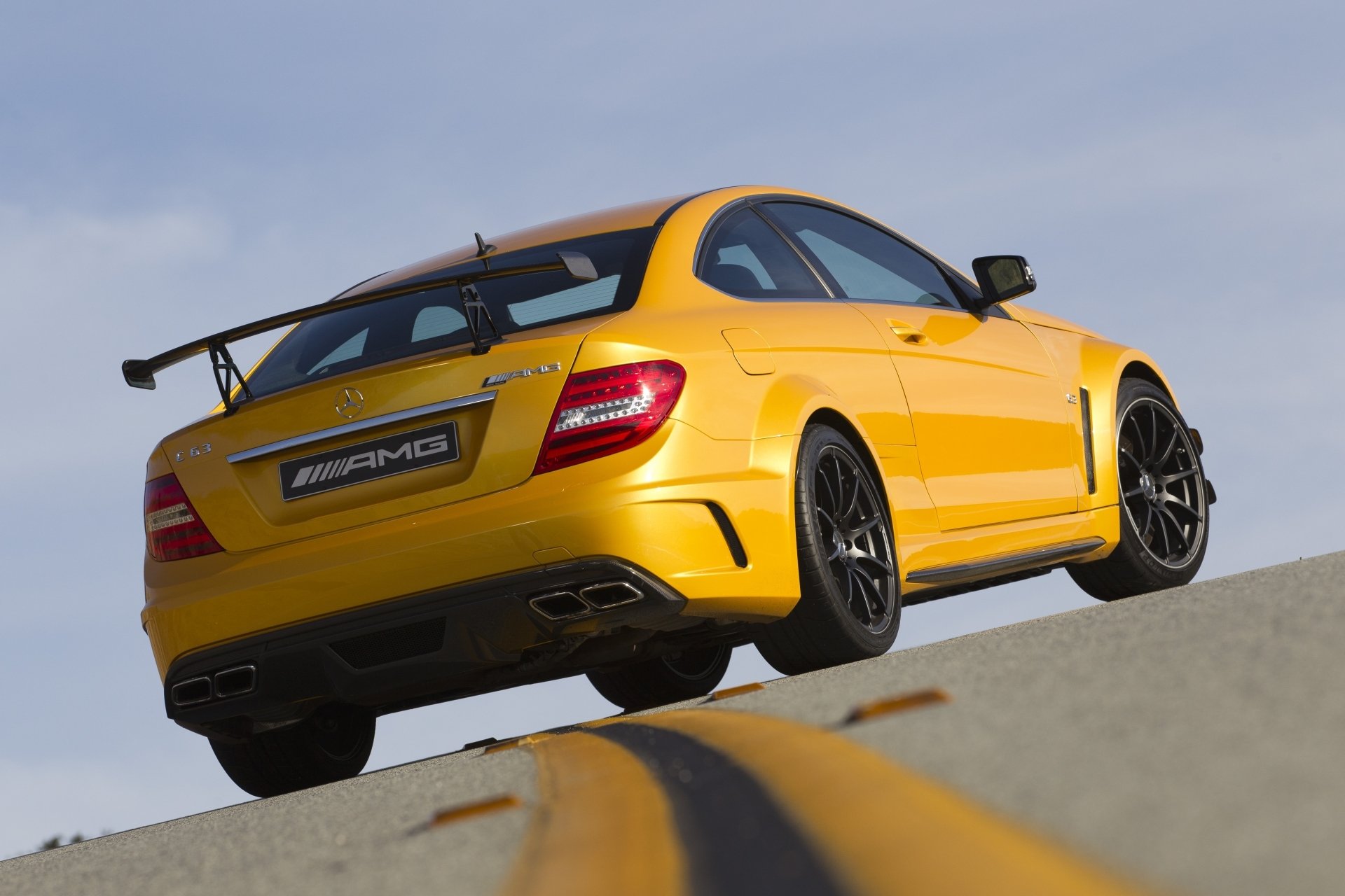 mercedes-benz c63 amg sire black series mercedes c63 amg black siries jaune supercar vue arrière piste de course balisage ciel