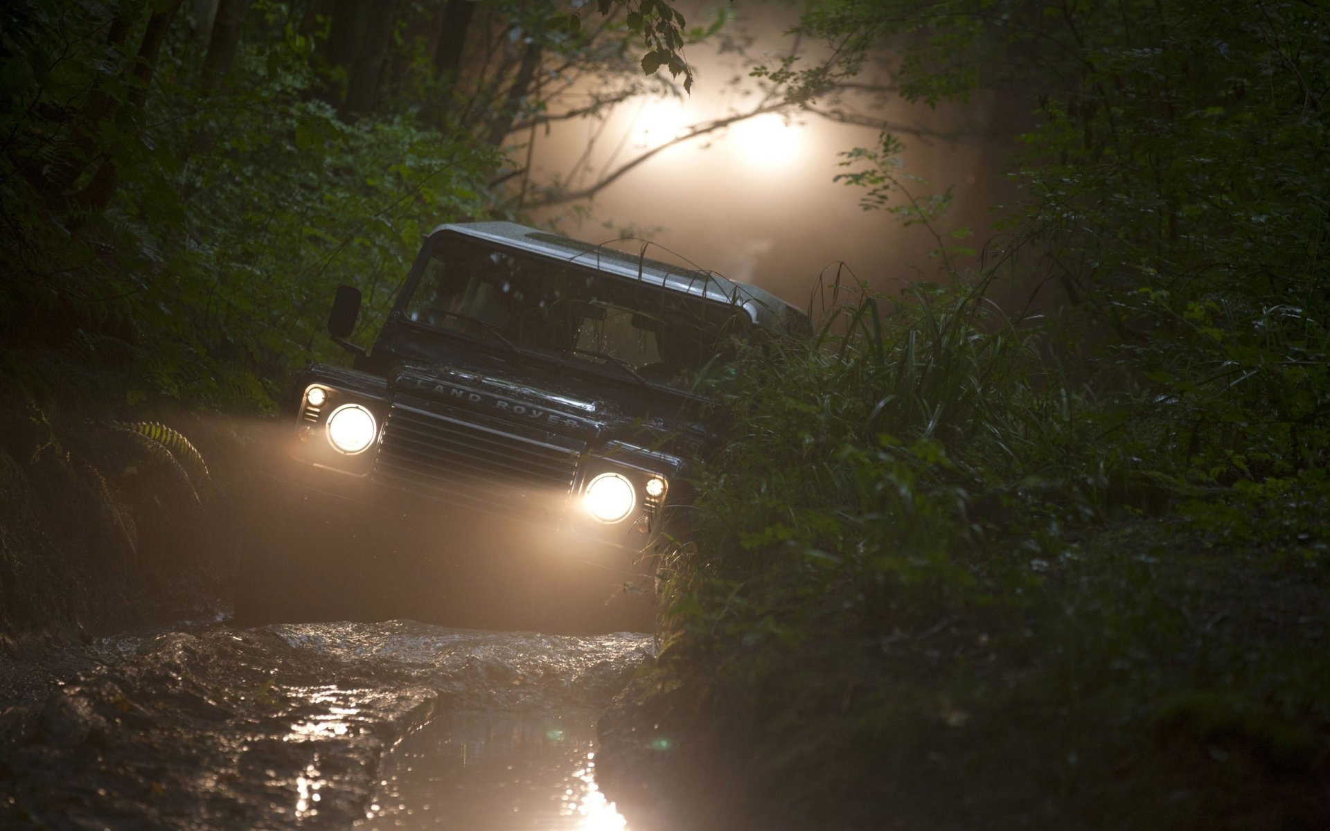 land rover defender land rover defender jeep suv.front scheinwerfer wald.schmutz hintergrund