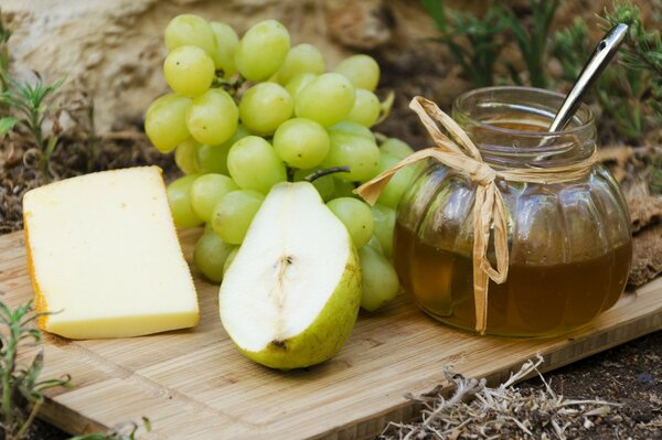 Carta da parati frutta formaggio miele su tavola di legno
