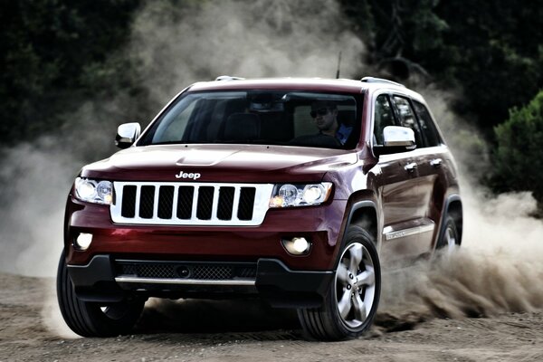 Jeep Cherokee rojo deriva/gira en la arena