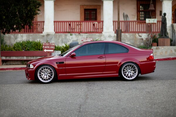 A red BMW is standing in the yard