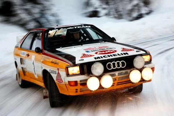 Audi fährt bei der Rallye mit hoher Geschwindigkeit durch den Schnee