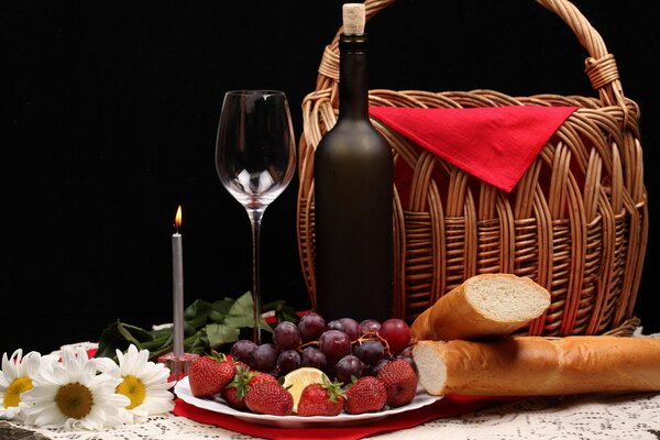 A bottle of red wine and a picnic basket