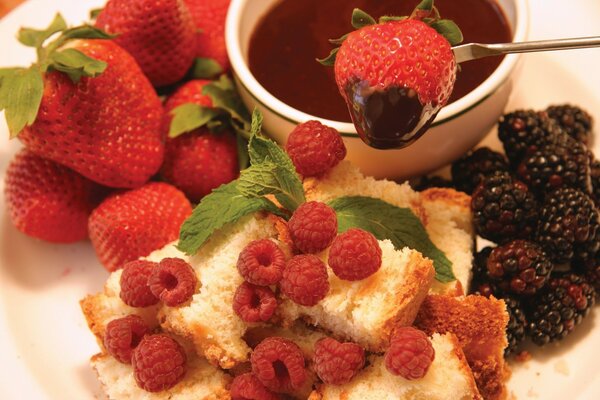 Chocolate fondue. Berries and sponge cake