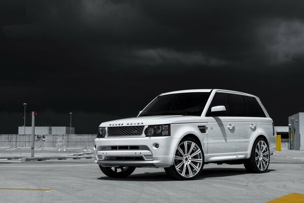 Land rover blanc sur fond de ciel noir