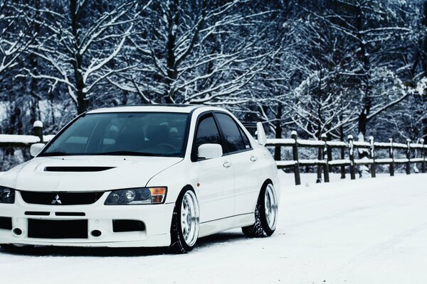 Mitsubishi Lancer blanco en la nieve en invierno