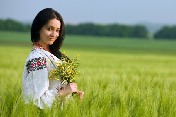 Ragazza in un campo di fiori in estate