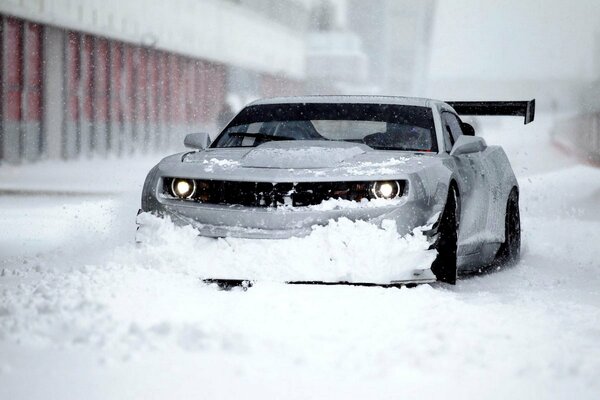 Зимний chevrolet camaro zl1 рассекает метель