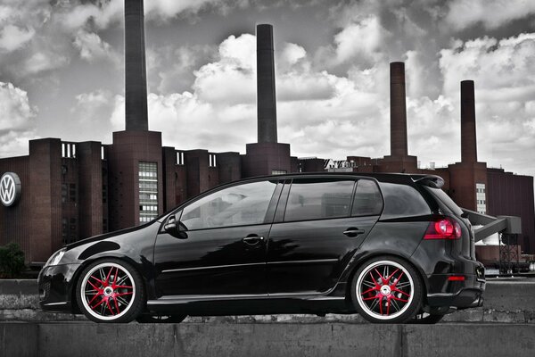 Coche de color negro en el fondo de la fábrica de Volkswagen