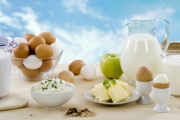 Produits laitiers et oeufs sur la table sur fond de ciel