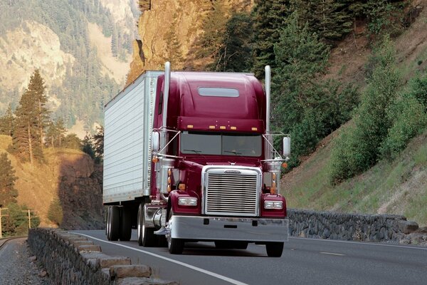 Un camion avec une cabine rouge Monte sur la pente