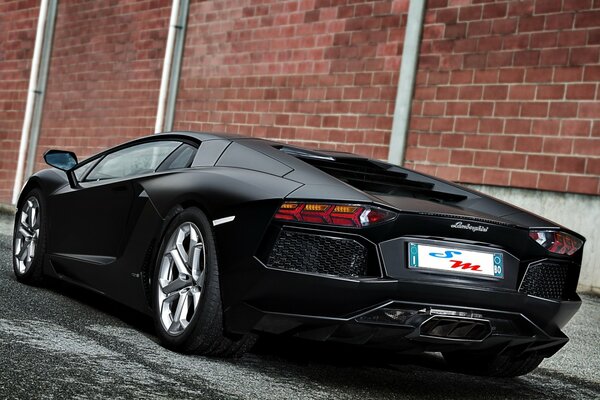 Lamborghini schwarz matt an der Mauer