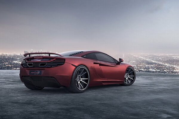 Red McLaren steht auf einem Spielplatz am Horizont, eine große Stadt ist sichtbar