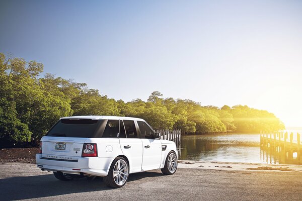 White Range rover on the shore at dawn