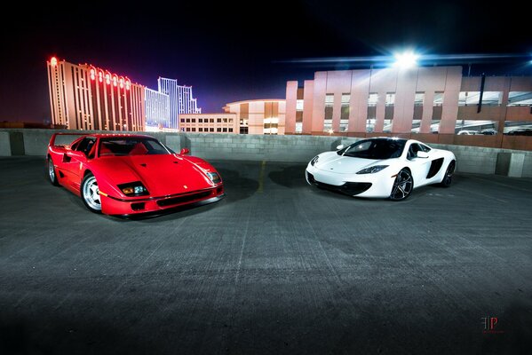 Rouge et blanc voiture Ferrari dans le stationnement dans la ville de nuit