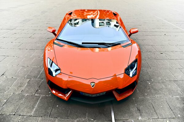 Pomarańczowy Lamborghini Aventador na kostce brukowej