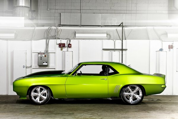 The car is a bright light green color against a white wall