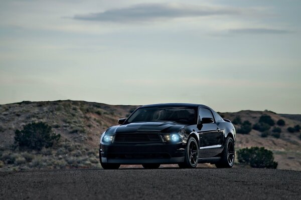 Czarny Ford Mustang na ponurym tle