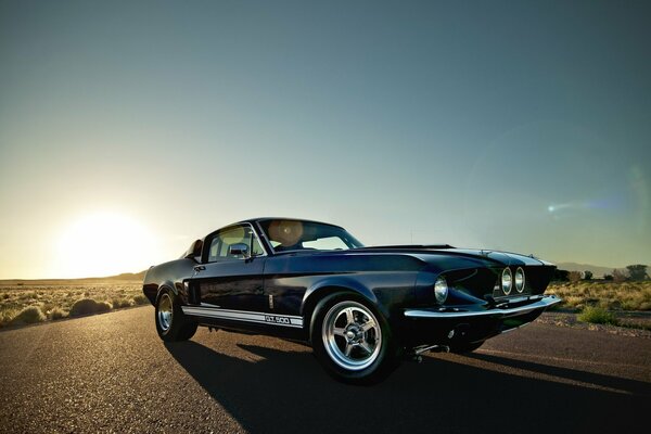 Ein Ford Mustang Auto auf einer sonnigen Straße in der Wüste